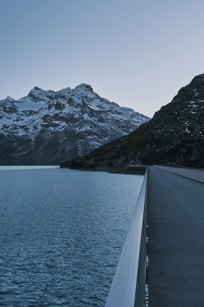 灰色的混凝土路面冰雪覆盖附近山区白天
